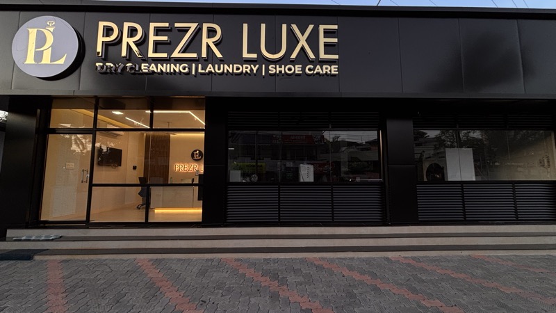 The Prezr Luxe studio seen from the road: a black building with gold signage above the glass frontage